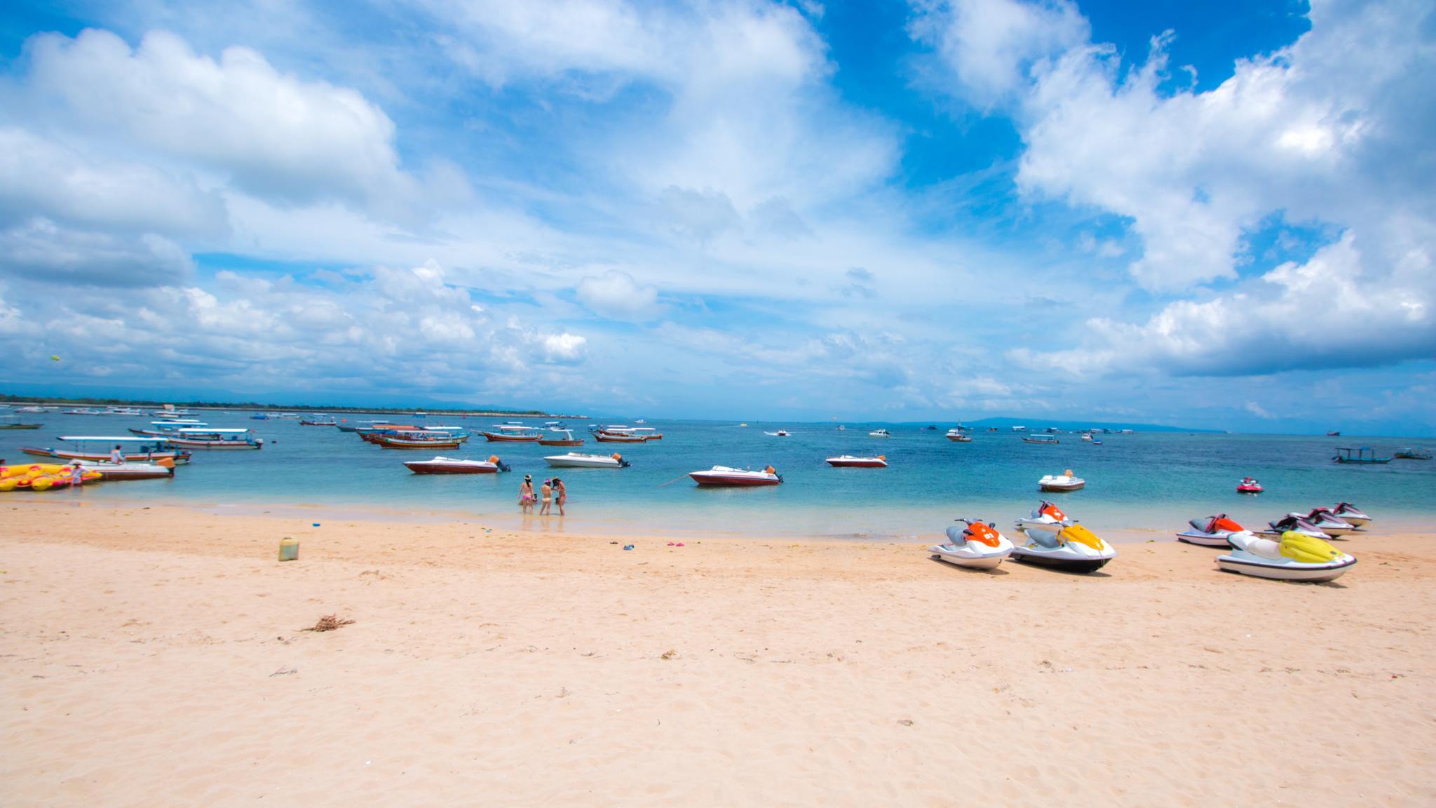 Ein heller Strand am Meer voller Boote